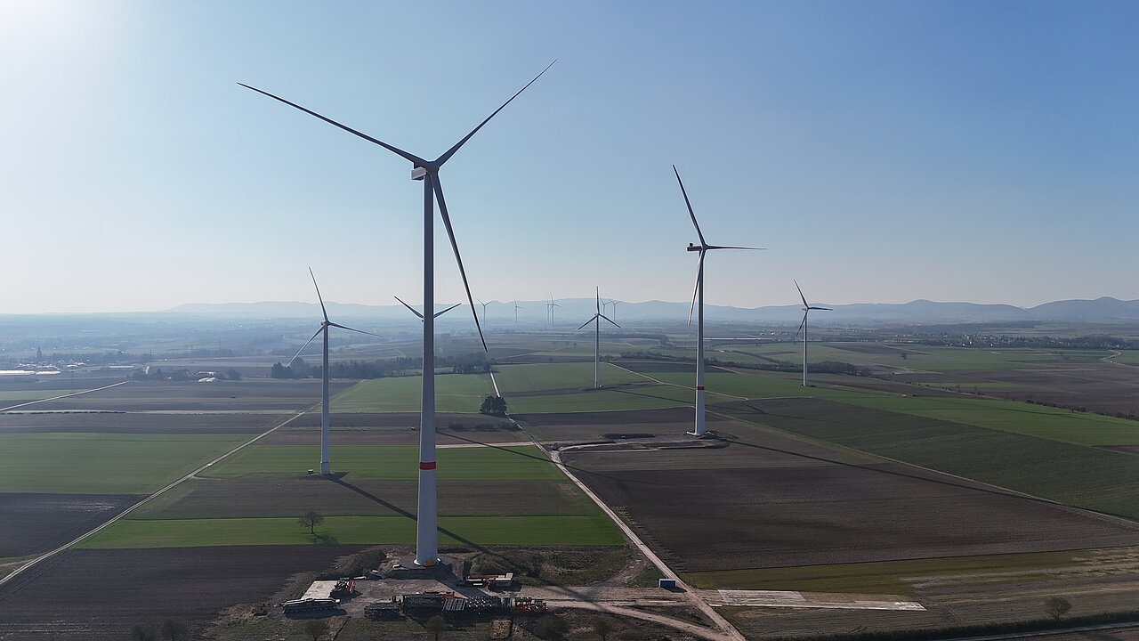Der fertige Windpark ist als Landschaftsbild mit mehreren Windenergie-Anlagen zu sehen.