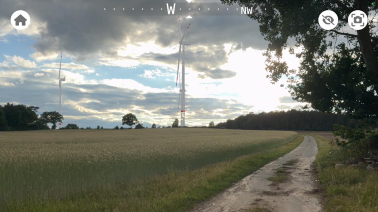 Feldweg mit Windenergieanlagen am Horizont
